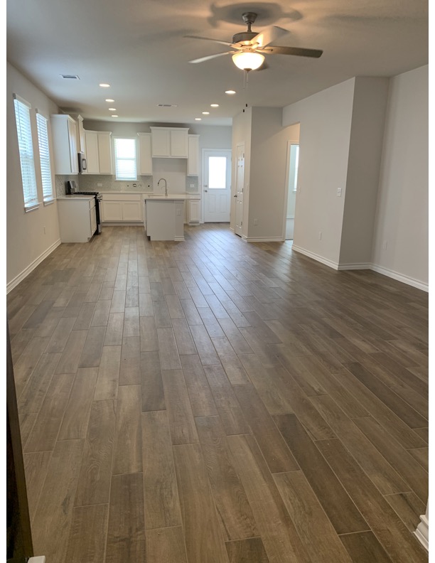 11715 Caithness Way Austin, TX 78653 - Photo 5 of 40 Unfurnished living room and dinner area with dark wood-type tile flooring, recessed lighting, and ceiling fan