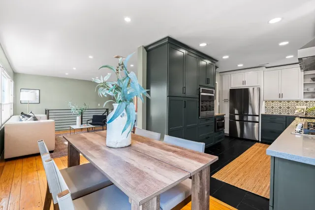 a kitchen with stainless steel appliances wooden floor dining table and chairs