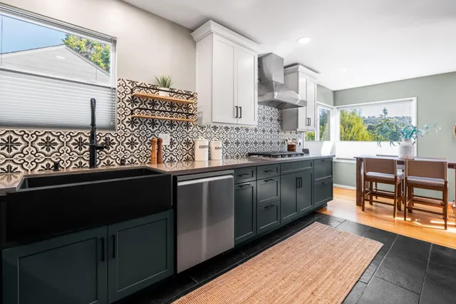 a kitchen with stainless steel appliances kitchen island granite countertop a sink stove and cabinets