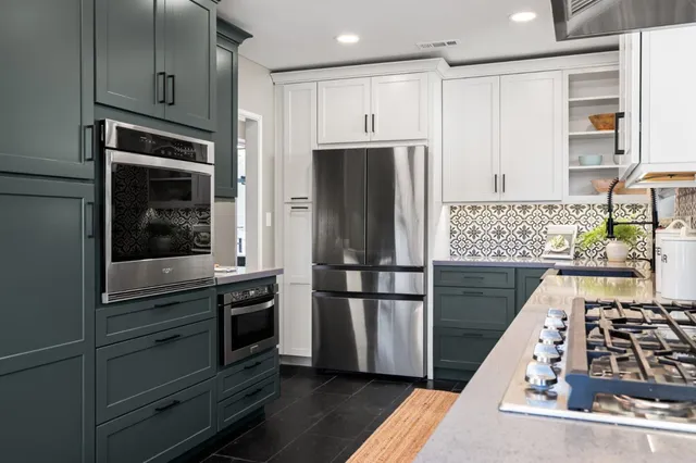 a kitchen with stainless steel appliances granite countertop a refrigerator and a stove top oven