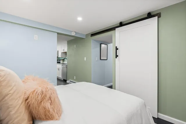 a bedroom with a bed and a painting on the wall