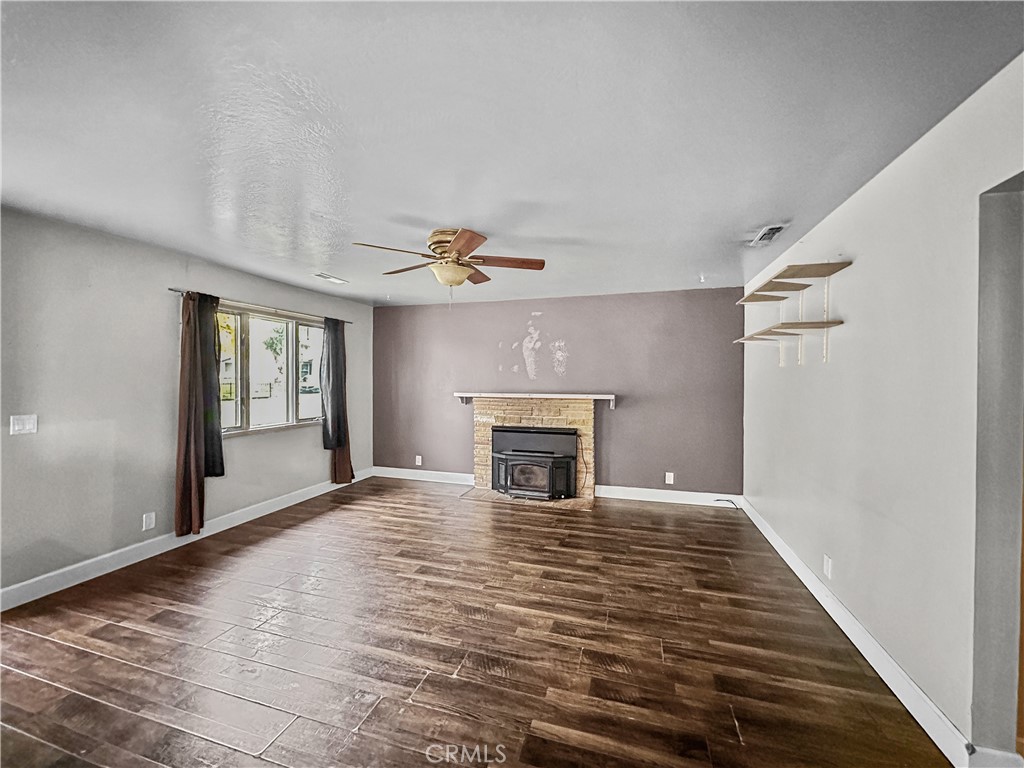 15 Regent Loop Oroville, CA 95966 - Photo 6 of 22 a view of an empty room with wooden floor fireplace and a window