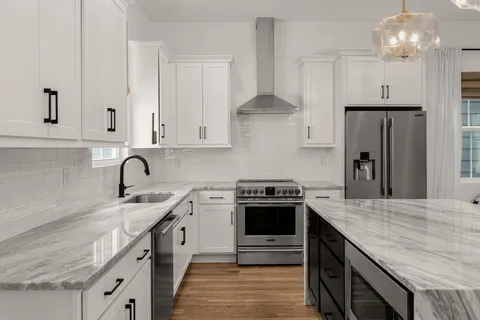 a kitchen with stainless steel appliances granite countertop a sink stove and refrigerator