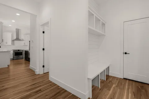 a view of a hallway with wooden floor and closet