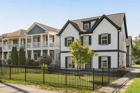 a front view of a house with a yard and plants