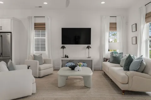 a living room with furniture a flat screen tv and a window