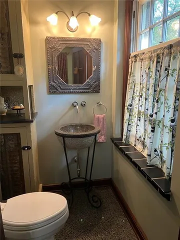 a bathroom with a toilet sink and mirror