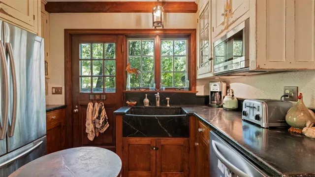 a kitchen with stainless steel appliances a stove a sink a refrigerator and cabinets