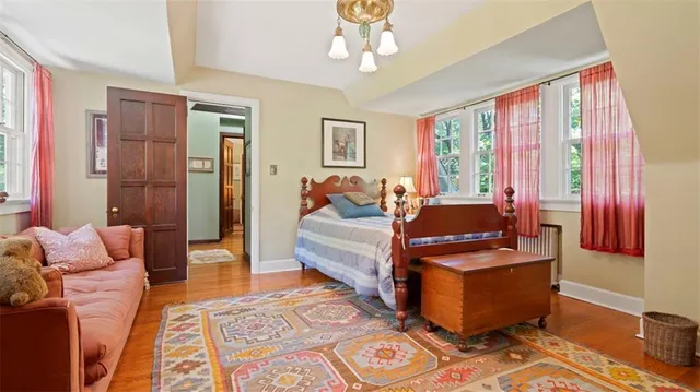 a bedroom with a bed a mirror on dresser and a window