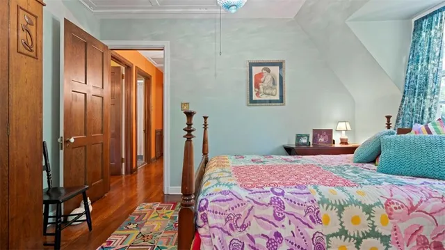 a bedroom with a bed and wooden floor