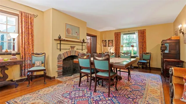 a dining room with furniture a fireplace and wooden floor