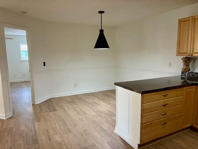 1550 South Belcher Road, Unit 211 Clearwater, FL 33764 - Photo 8 of 26 a kitchen with a wooden floor and white cabinets