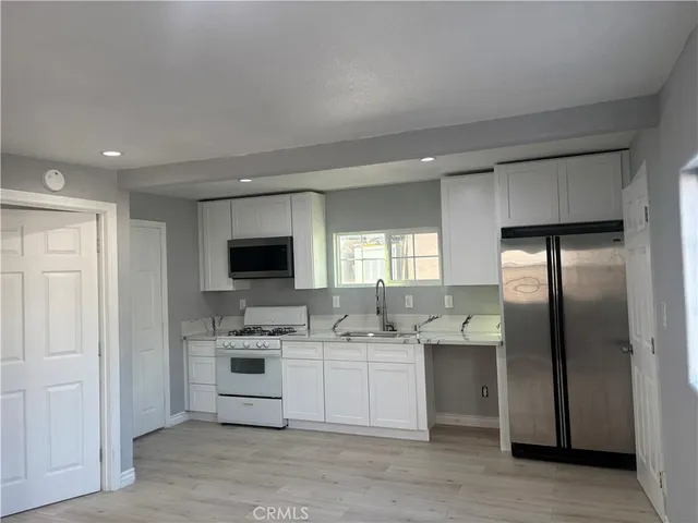 a kitchen with stainless steel appliances kitchen island a refrigerator sink and cabinets