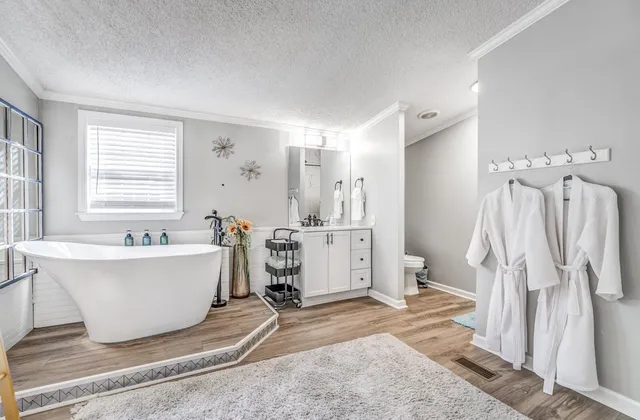 a bathroom with a granite countertop sink a mirror and shower