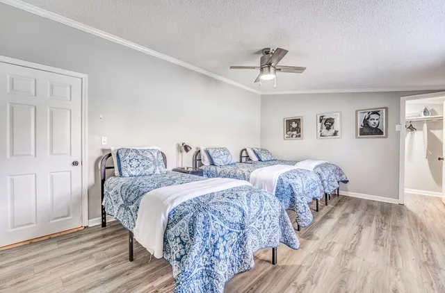 a bedroom with a large bed and a flat tv screen on dresser