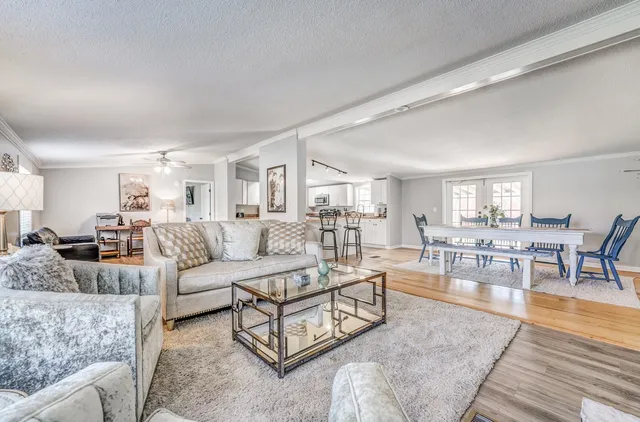 a living room with furniture wooden floor and a table