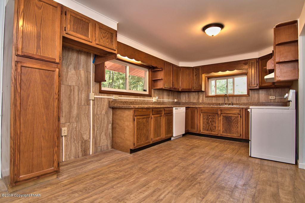 1103 Cameron Road Effort, PA 18330 - Photo 11 of 40 a kitchen with stainless steel appliances granite countertop a stove top oven a sink dishwasher and a refrigerator with wooden floor