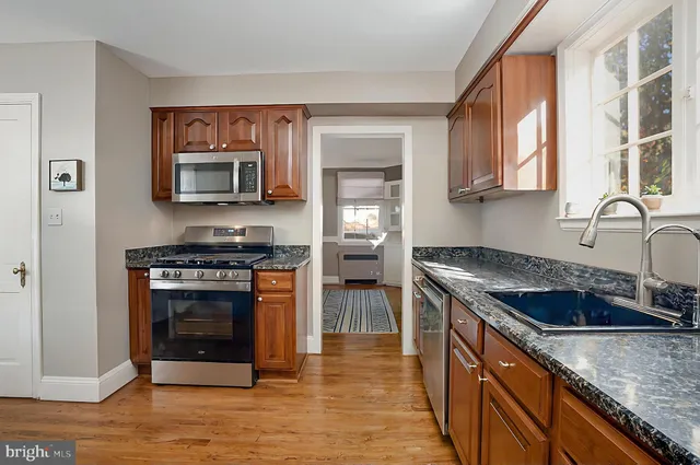 a kitchen with granite countertop a stove and a microwave