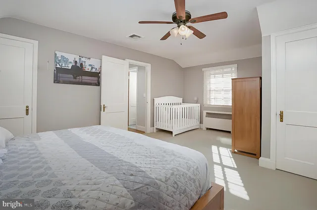a spacious bedroom with a bed and a chandelier