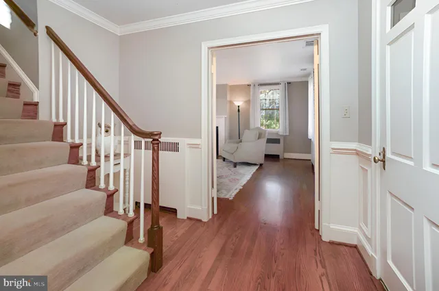 a view of a hallway with wooden floor and staircase