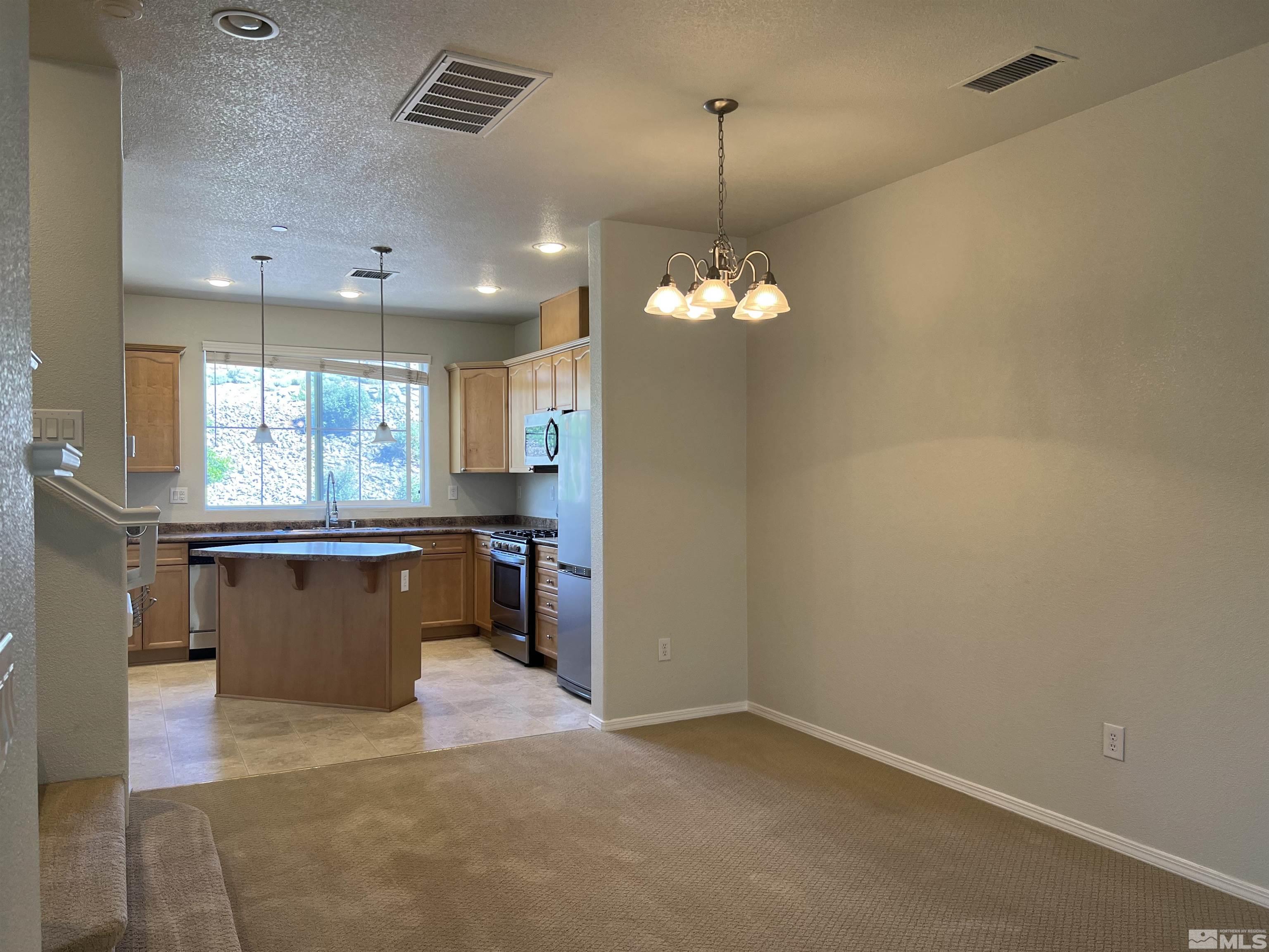 3078 Sterling Ridge Circle Sparks, NV 89431 - Photo 2 of 16 an empty room with window and chandelier
