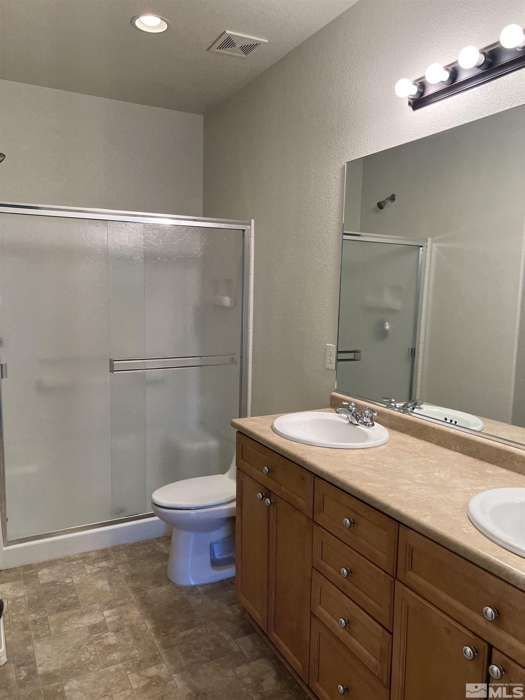 3078 Sterling Ridge Circle Sparks, NV 89431 - Photo 4 of 16 a bathroom with a granite countertop sink a toilet and a mirror
