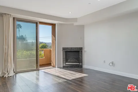 a living room with a fireplace and a wooden floor