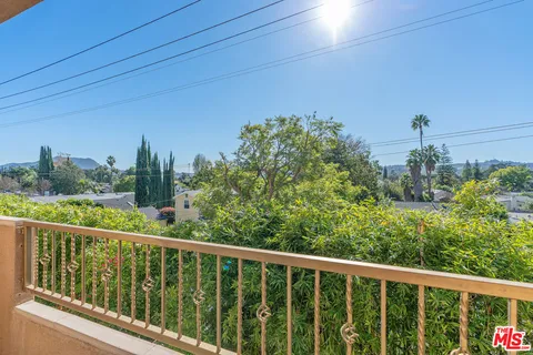 a view of a room with wooden floor and kitchen view