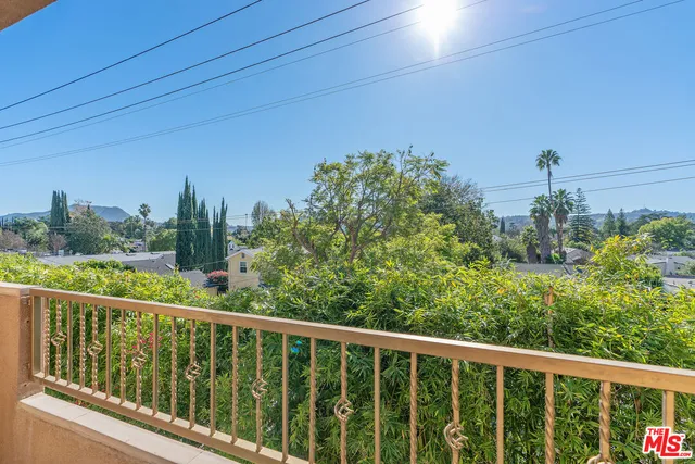 a view of a room with wooden floor and kitchen view