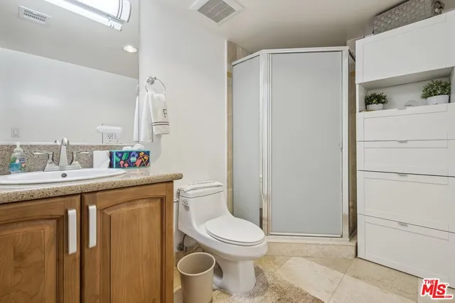 a bathroom with a granite countertop toilet sink and a mirror