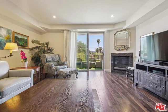 a living room with furniture a fireplace a flat screen tv and a large window