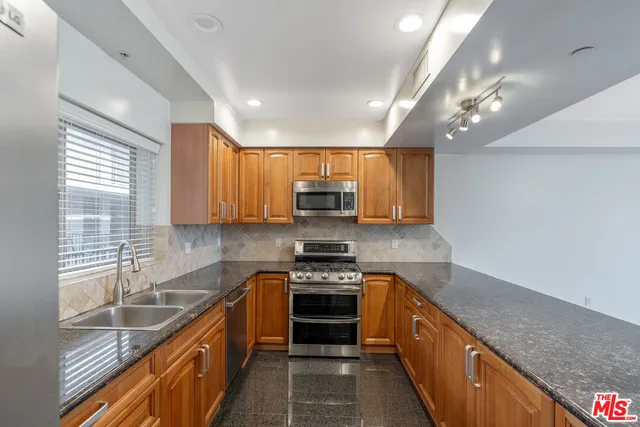 a view of a kitchen center island and stainless steel appliances