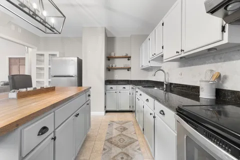 a kitchen with granite countertop a sink stainless steel appliances and cabinets