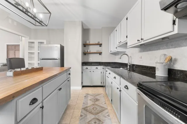 a kitchen with granite countertop a sink stainless steel appliances and cabinets