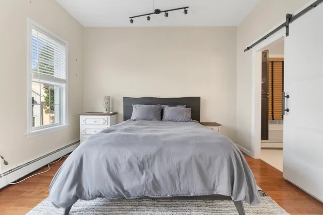 a bedroom with a bed and wooden floor