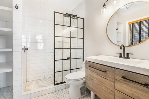 a bathroom with a sink a toilet and shower