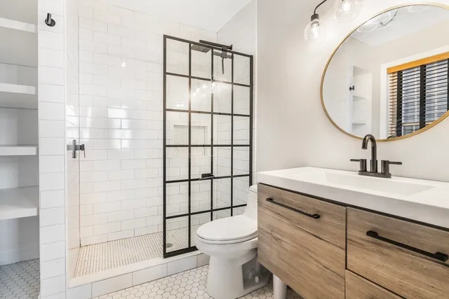 a bathroom with a sink a toilet and shower