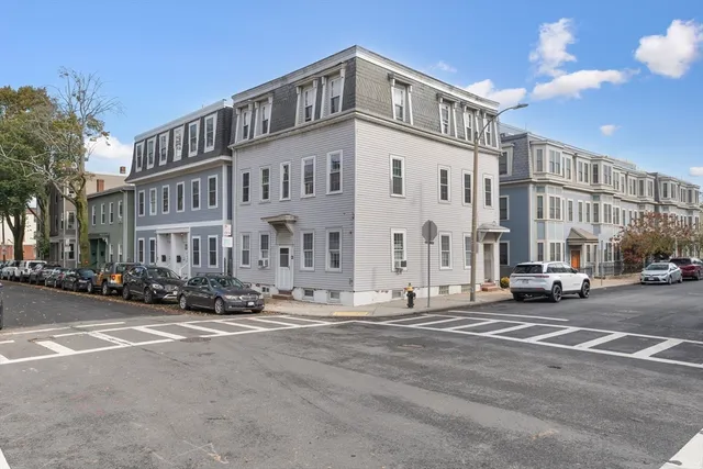 a city street lined with parked cars and buildings