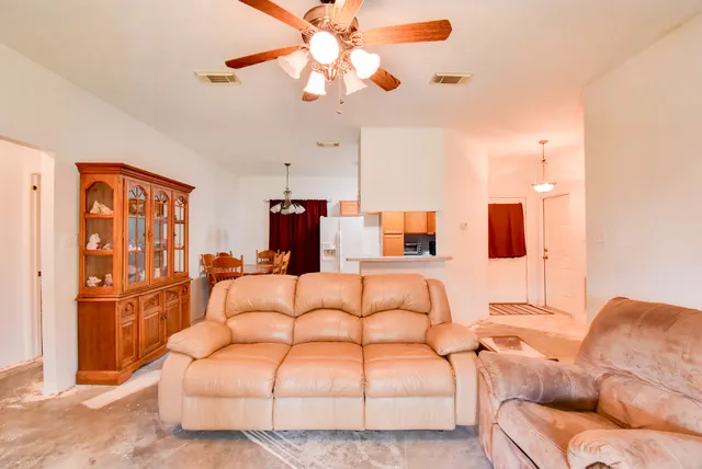a living room with furniture a ceiling fan and a rug