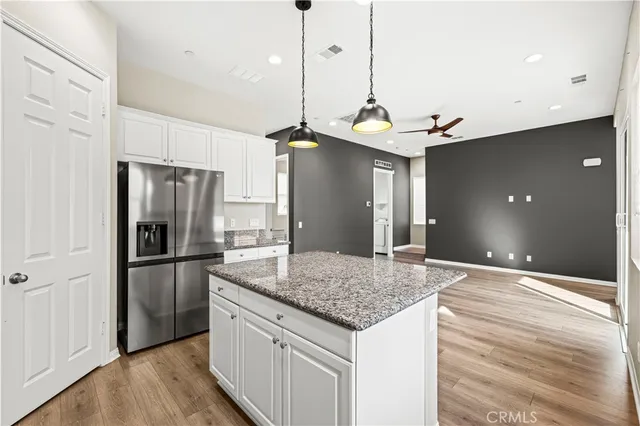 a kitchen with stainless steel appliances granite countertop a refrigerator a sink and a stove