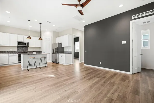 a view of kitchen with stainless steel appliances refrigerator stove microwave and cabinets