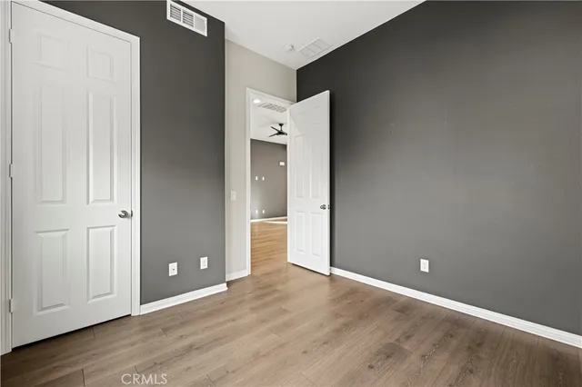 an empty room with wooden floor and closet