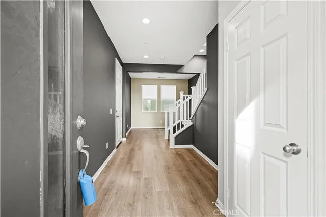 a view of a hallway with wooden floor and staircase