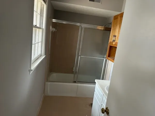 a bathroom with a glass door shower and tub
