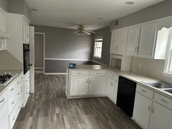 a kitchen with sink cabinets and wooden floor