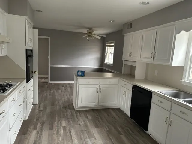 a kitchen with sink cabinets and wooden floor