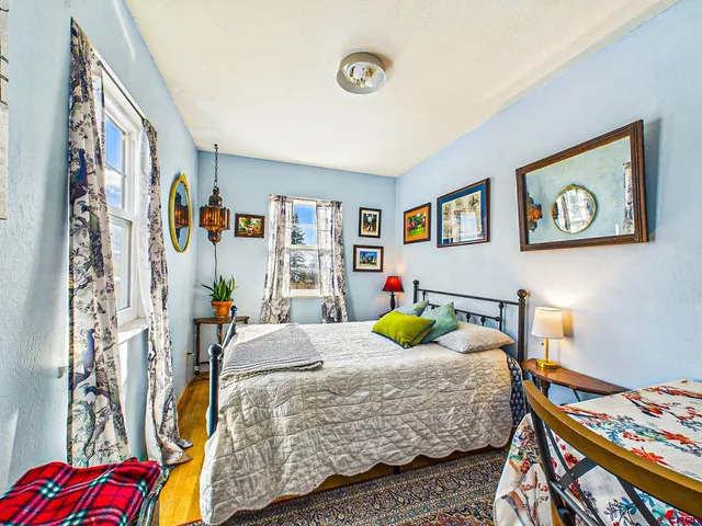 a bed sitting in a bedroom next to a window