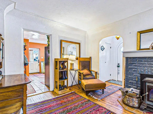 a living room with furniture a fireplace and a large window