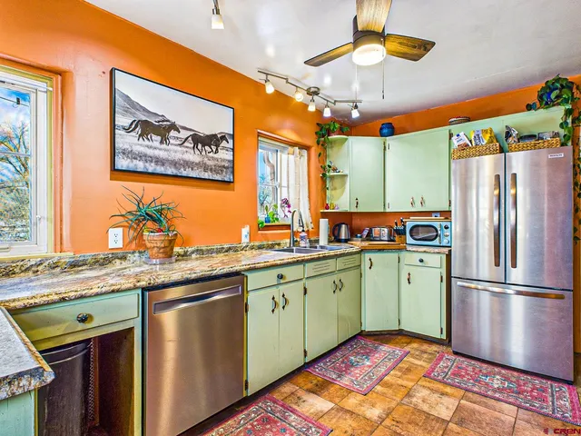 a kitchen with stainless steel appliances granite countertop a refrigerator and a stove