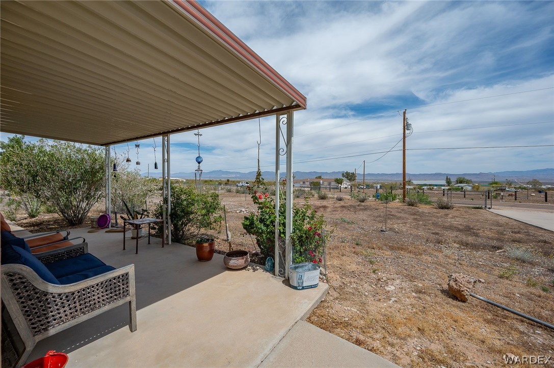 2465 Egar Road Golden Valley, AZ 86413 - Photo 8 of 98 The property features a covered patio with a concrete floor, offering views of the surrounding landscape and distant mountains